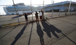 People in Yokohama, Japan, look at the cruise ship Diamond Princess, where dozens of passengers tested positive for coronavirus