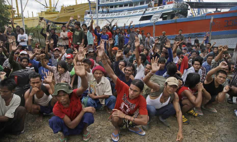 In this April 2015 file photo, Burmese fishermen raise their hands as they are asked who wants to go home at the compound of Pusaka Benjina Resources fishing company in Benjina, Aru Islands, Indonesia.