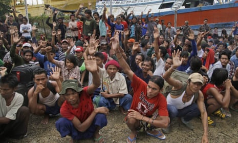 Myanmarese fishermen raise their hands as they are asked who among them wants to go home, at a port in Indonesia, April 2015. 