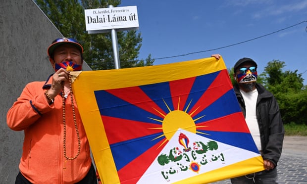 Activists hold the Tibetan flag underneath a street sign reading ‘Dalai Lama Road’, close to the planned Chinese Fudan university campus in Budapest.