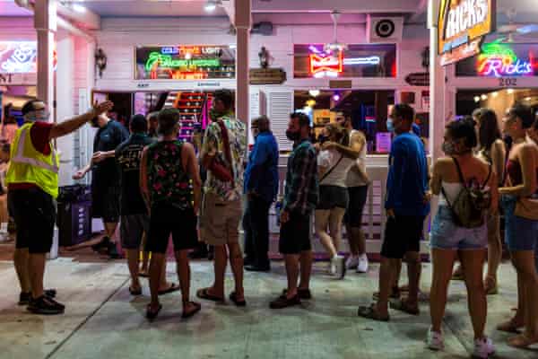 Code enforcement inspector Troy Montero (R) makes sure people waiting online to enter a bar/restaurant social distance and wear protective face masks in Key West, Florida on September 18, 2020. Photograph: Saul Martinez