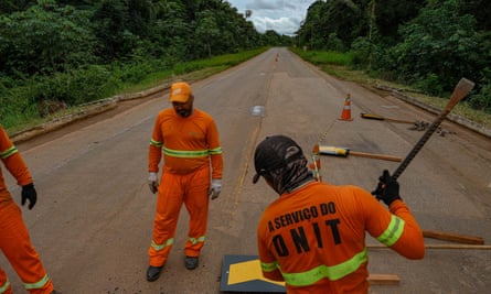 Workers carry out maintenance on a paved stretch of the BR-319