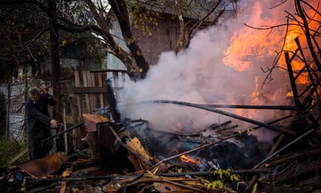 A local resident works to extinguish a fire after shelling in the town of Bakhmut, in eastern Ukraine’s Donbas region.