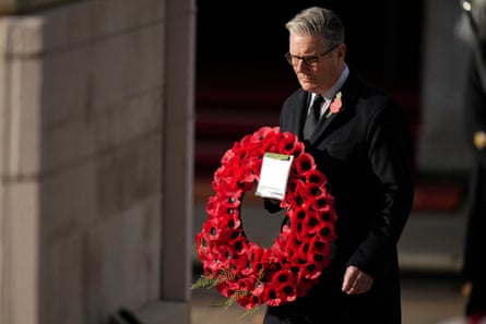 Keir Starmer approaches the Cenotaph holding a poppy wreath
