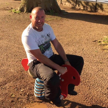 Carrick sitting on a child’s playground ride.