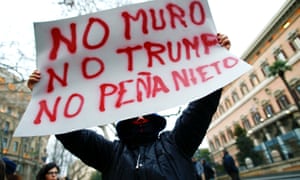 A demonstrator holds a placard saying: ‘No wall, no Trump, no Peña Nieto.’