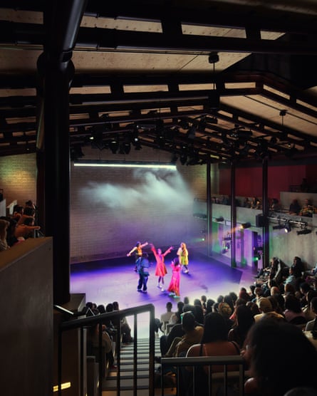 Dancers in colourful costumes perform on a smoky, lit stage at the Yard Theatre
