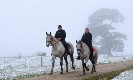 Residents ride their horses as snow falls near Greendale, Victoria on Friday