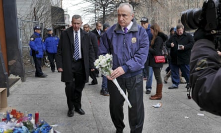 New York City police commissioner Bill Bratton leaves flowers at an impromptu memorial.