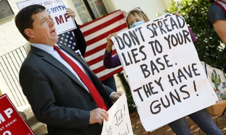 A pro-Biden supporter, right, quietly interrupts pro-Trump political operative Ed Martin, left, as he speaks at a 'Stop the Steal' rally outside of the Republican National Committee office on 6 November.