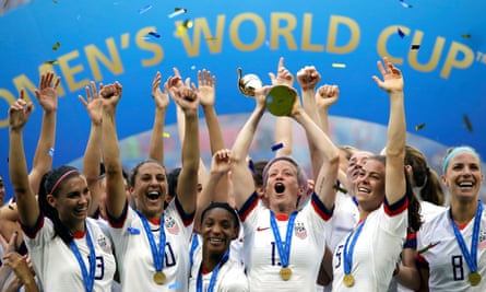 Megan Rapinoe lifts the trophy surrounded by her USA teammates after winning the Women's World Cup final in 2019