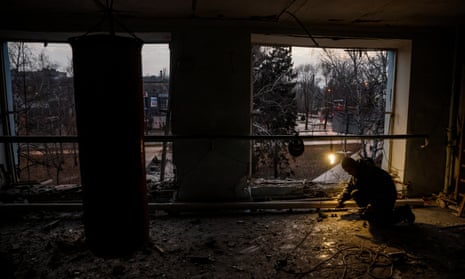 A local resident repairs central heating at a children’s sports centre after it was hit by shelling in downtown Donetsk