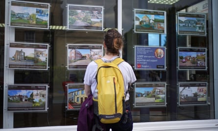 Woman looking at ads in an estate agent’s window
