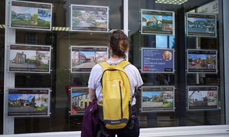 Woman looking at ads in an estate agent’s window