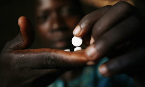 A woman infected with the HIV virus takes her pills at a refugee camp near Gulu in Uganda, where funding problems have led to a shortage of the antibiotic Septrin. 