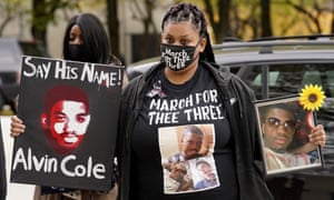 Tristiana Cole holds a sign and a photo of her brother Alvin Cole as she arrives for a Get Out The Vote rally in Chicago in October.