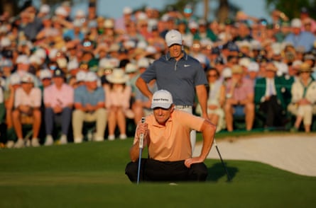 Rory McIlroy watches as Justin Rose lines up a putt on the 18th hole, the 1st playoff hole