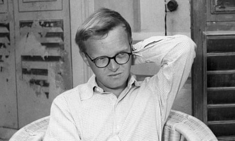 Truman Capote sitting on a wicker chair