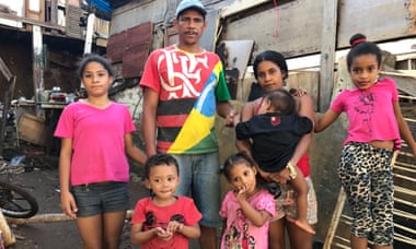 Sérgio Conceição and Edeane Silva with their children and a friend in front of their house.