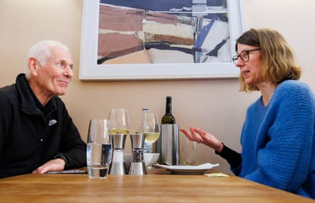 A man and woman facing each other across a restaurant table
