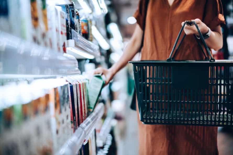 A shot of a woman selecting a carton at a grocery store.