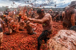 Revellers participate, covering each other in tomatoes