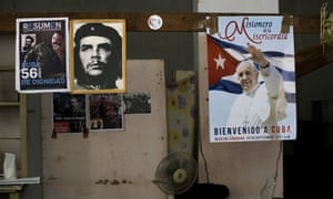 A poster of Pope Francis hangs next to a picture of revolutionary hero Ernesto Che Guevara, center, and Fidel Castro inside a government-run store that sells flour and beans in Havana, Cuba, on Friday/
