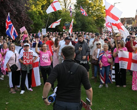 An anti-migrant protest with people waving English flags