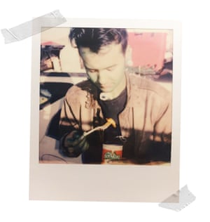 A member of the punk band Foreign Life Form, body painted green, eating a can of Chef Boyardee at his campsite.