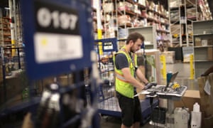 Workers pack and ship customer orders at an Amazon fulfillment center in Romeoville, Illinois.