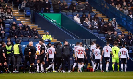 Players leave the pitch with the match called off due to a medical emergency in the crowd