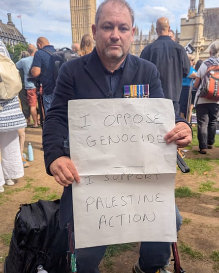 Steve Masters holds a sign saying: âI oppose genocide. I support Palestine Actionâ