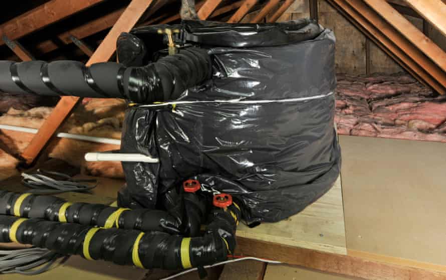 Home attic roof space with lags in pipes and cold water storage tanks to reduce the risk of freezing and pipe rupture.