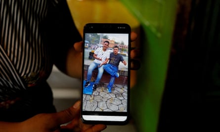 Lucía Pacheco, sister of Carlos Alberto Pacheco Gutiérrez, who died during a fire at a migrant detention center in Ciudad Juárez shows a picture of her brother and her nephew Marvin García, who were traveling together, in El Salvador.