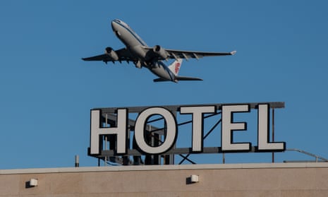 An airplane passes over a Sofitel hotel as it takes off from a runway at Heathrow Airport