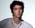 Portrait of Australian musician Troye Sivan, with dark hair, wearing a distressed grandad top over a t-shirt