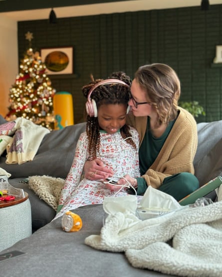 A woman and a young girl sitting on a sofa.