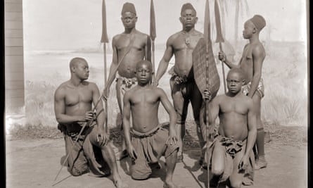 Congolese men pose in front of a painted backdrop for the world fair in Antwerp in 1894.