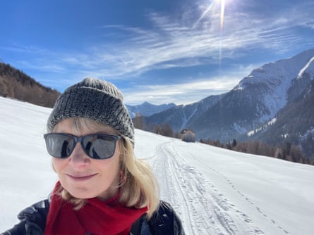 Woman in hat and sunglasses in the snowy nountauns on a sunny day