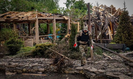 Law enforcement officers work at the site of a Russian missile strike after an attack in Cherkasska Lozova, in the Kharkiv region of Ukraine.