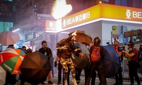 A pro-democracy protester throws a fire bottle towards riot police during a rally against police brutality in Hong Kong, China, 27 October 2019