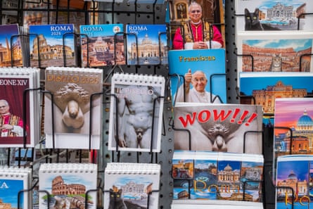 Souvenirs depicting religious figures and landmarks are displayed at a tourist kiosk in central Rome