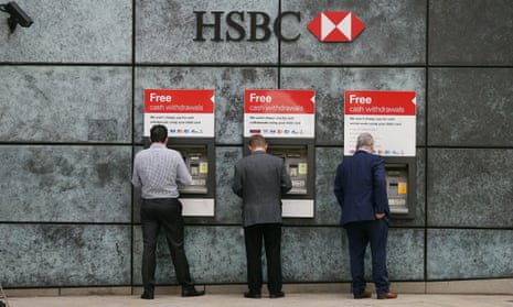 People withdraw money from a cash machine at a HSBC branch in London.