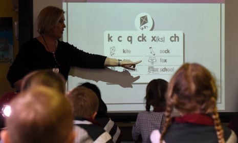 A teacher points at a board during a lesson 