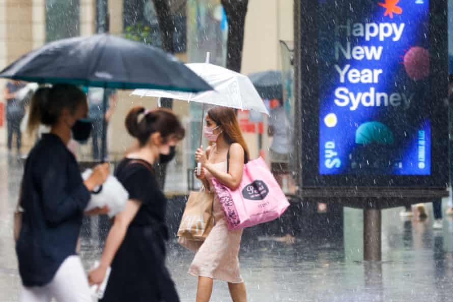 Christmas shoppers are seen in the CBD during a rain storm on December 23, 2021 in Sydney, Australia.