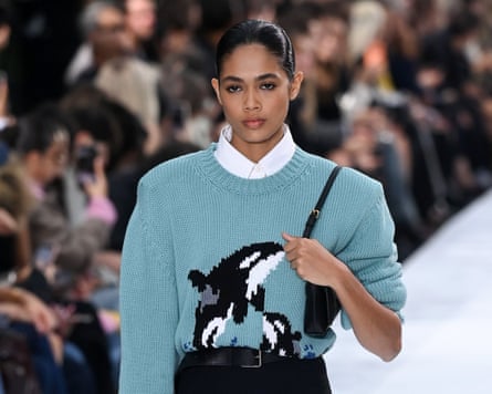 A model walks the catwalk wearing a blue jumper with great white sharks on it