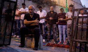 Palestinian worshippers pray between police security barriers in the street outside the Lionsâ Gate entrance to the compound.