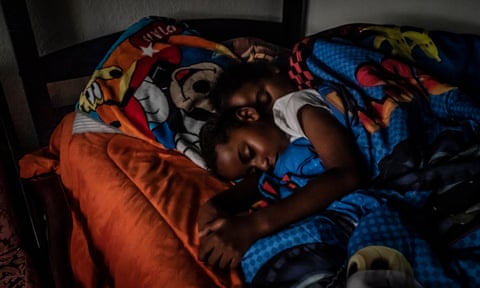 Cherokeena Robinson, 32, lays in bed with her son Mai’Kel Stephens, 6, at their transitional house in San Pedro, California.