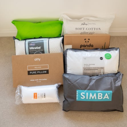 Group shot of eight pillows, still boxed or bagged, on a carpeted floor.