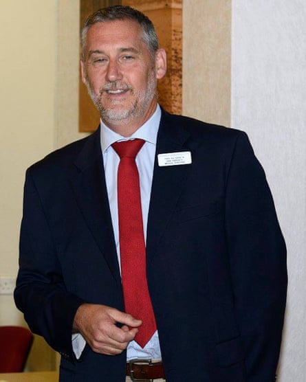 Ian Harvey posing for a photo in a suit and tie